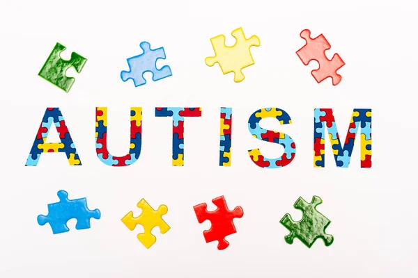 Vista dall'alto di Autismo puzzle lettering isolato su bianco — Foto stock