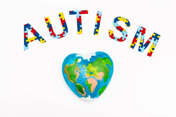 Vista dall'alto di Autismo puzzle lettering e globo isolato su bianco — Foto stock