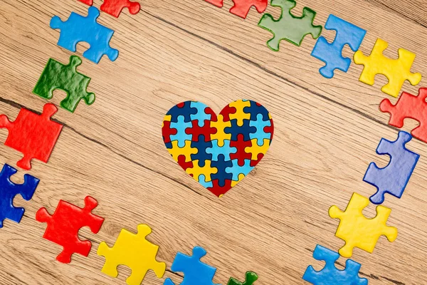 Vista dall'alto del cuore puzzle su sfondo di legno, concetto di autismo — Foto stock