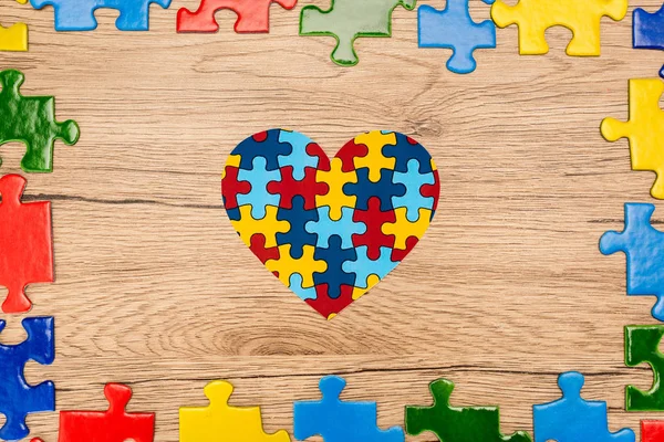 Top view of puzzle heart on wooden background, autism concept — Stock Photo