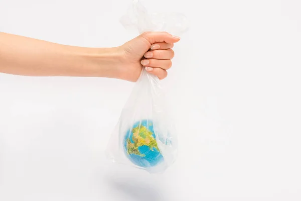 Cropped view of woman holding plastic bag with globe on white background, global warming concept — Stock Photo