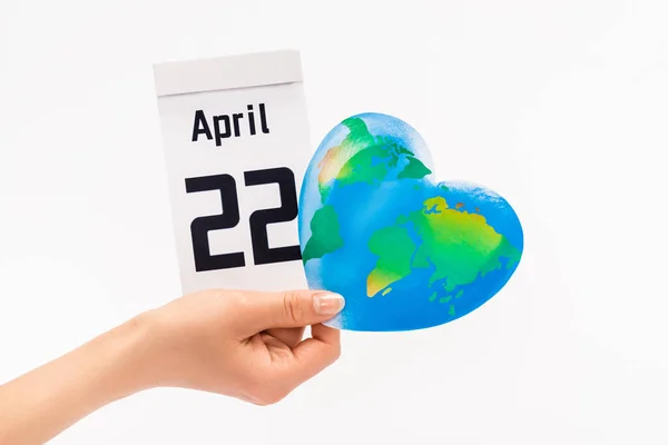 Vista recortada del calendario de celebración de la mujer con 22 inscripción de abril y globo aislado en blanco, concepto de día de la tierra - foto de stock