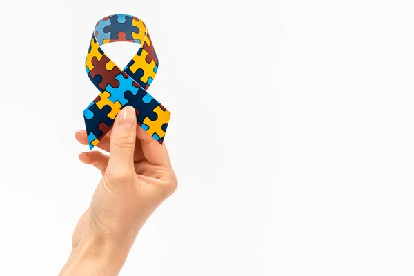 Cropped view of woman holding awareness ribbon isolated on white, autism concept — Stock Photo