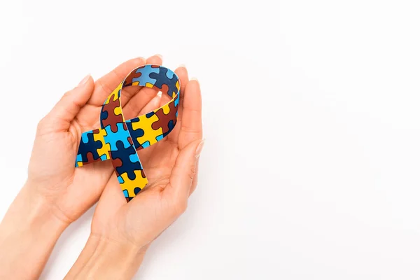Vista ritagliata del nastro di consapevolezza nelle mani femminili sul bianco, concetto di autismo — Stock Photo