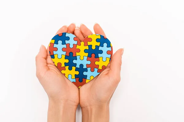 Cropped view of puzzle heart in female hands on white background, autism concept — Stock Photo