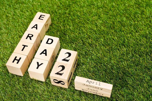 High angle view of cubes with earth day and 22 april lettering on green background — Stock Photo