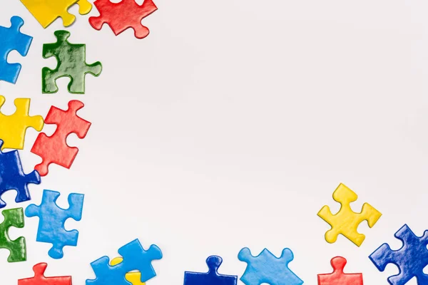Vista superior de peças coloridas de quebra-cabeça sobre fundo branco, conceito de autismo — Fotografia de Stock