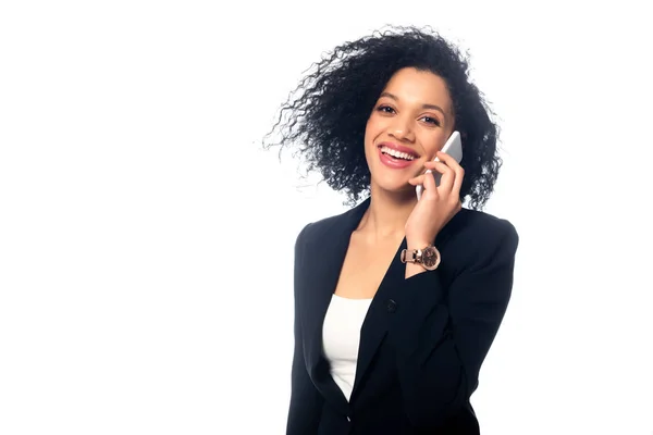 Femme d'affaires afro-américaine réussie parlant sur smartphone, souriant et regardant la caméra isolée sur blanc — Photo de stock