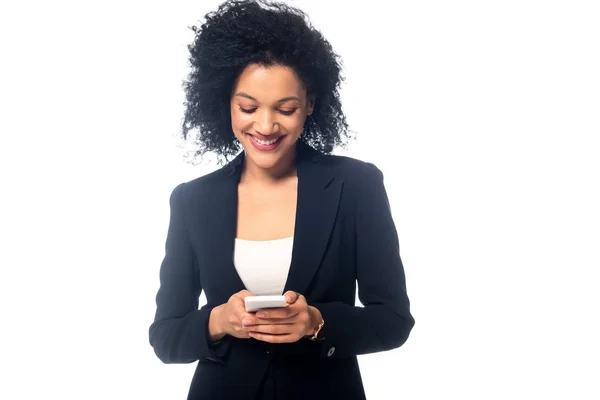 Front view of african american businesswoman holding smartphone and smiling isolated on white — Stock Photo