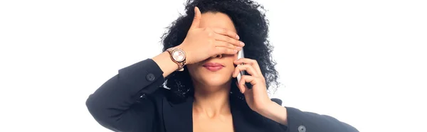 Africano americano mulher falando no smartphone e cobrindo rosto isolado em branco, tiro panorâmico — Fotografia de Stock