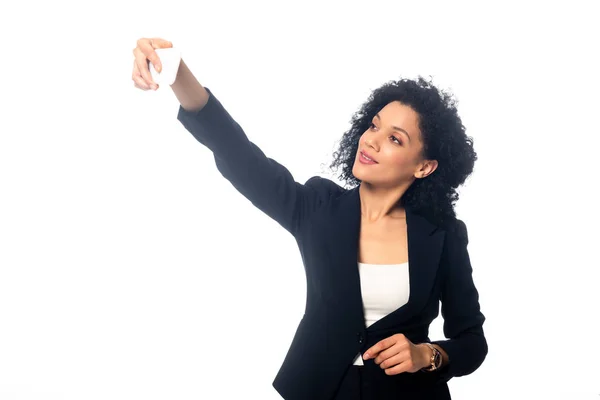 Vista frontal de una empresaria afroamericana tomando selfie y sonriendo aislada en blanco - foto de stock