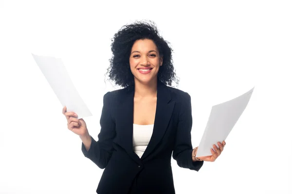 Front view of successful african american businesswoman holding papers, smiling and looking at camera isolated on white — Stock Photo