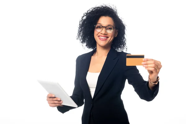 Африканская американская деловая женщина держит цифровой планшет, улыбаясь и показывая кредитную карту изолированы на белом — стоковое фото