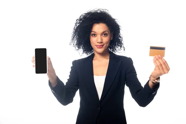 Afroamerikanische Geschäftsfrau präsentiert Kreditkarte und Smartphone und blickt isoliert auf weiße Kamera — Stockfoto