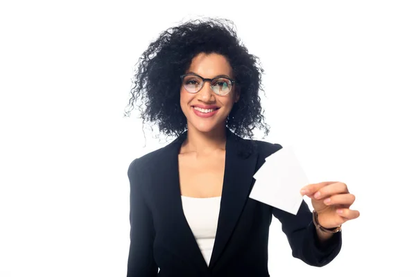 Vue de face de la femme d'affaires afro-américaine souriante et montrant des cartes de visite isolées sur blanc — Photo de stock