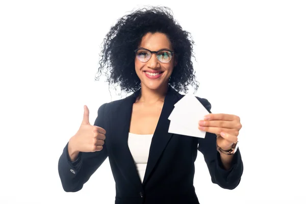 Feliz mujer de negocios afroamericana mostrando el pulgar hacia arriba y tarjetas de visita aisladas en blanco - foto de stock