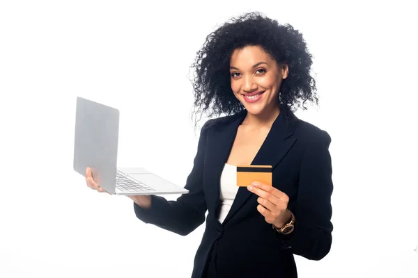 Щаслива афроамериканська бізнесменка з ноутбуком, що показує кредитну картку і дивиться на камеру, ізольовану на білому. — стокове фото