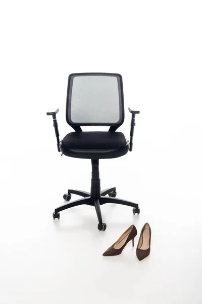 Chaise de bureau noire et chaussures sur fond blanc — Photo de stock