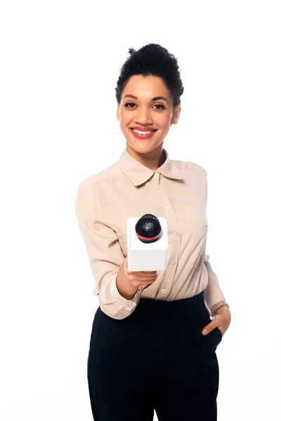 Vista frontale del giornalista afroamericano con microfono sorridente isolato su bianco — Foto stock