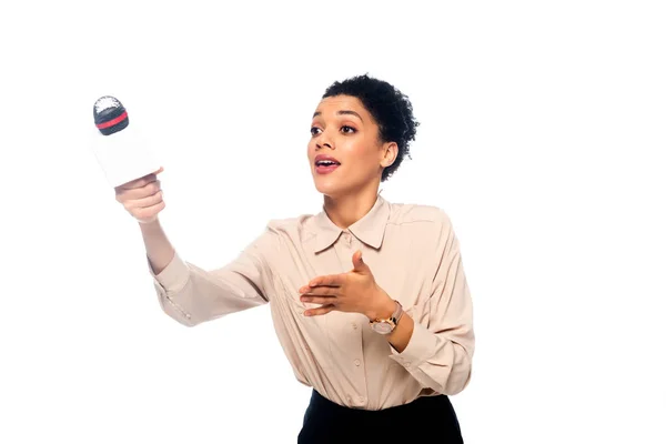 Periodista afroamericano extendiendo la mano con micrófono aislado en blanco - foto de stock