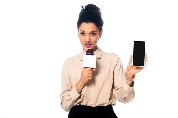 African american journalist speaking into microphone and presenting smartphone isolated on white — Stock Photo