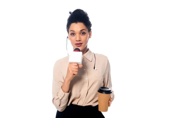 Jornalista afro-americano com fones de ouvido e xícara de café descartável falando em microfone isolado em branco — Fotografia de Stock