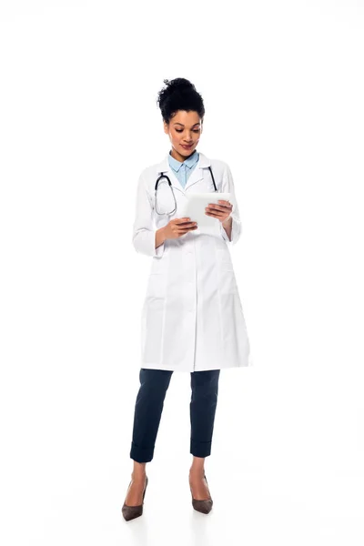 Vorderansicht eines afrikanisch-amerikanischen Arztes mit Stethoskop, der Papiere in Händen auf weißem Hintergrund betrachtet — Stockfoto