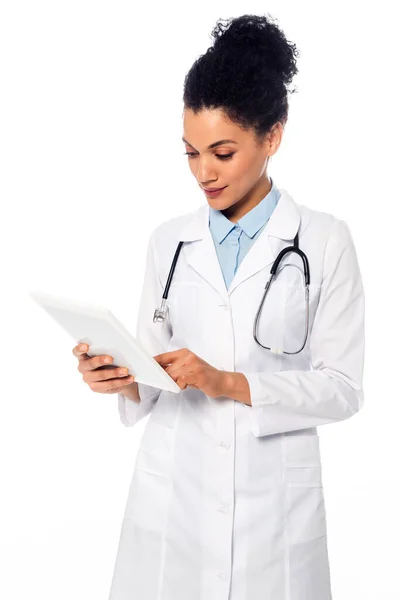 Vista frontale del medico afro-americano con stetoscopio utilizzando tablet digitale isolato su bianco — Foto stock