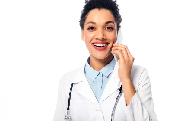 Vue de face du médecin afro-américain heureux avec stéthoscope parlant sur smartphone isolé sur blanc — Photo de stock