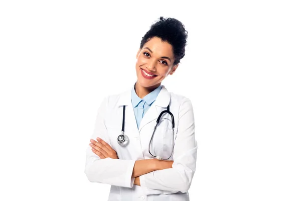 Vista frontal del médico afroamericano con estetoscopio y brazos cruzados sonriendo aislado en blanco - foto de stock