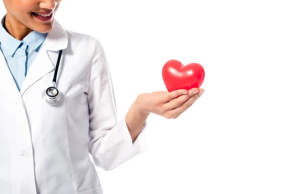 Vista recortada del médico afroamericano que presenta corazón rojo decorativo aislado en blanco - foto de stock