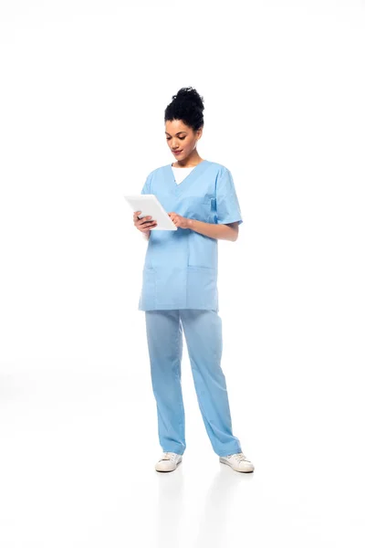 Vollständige Ansicht der afrikanisch-amerikanischen Krankenschwester mit Stethoskop mittels digitalem Tablet auf weißem Hintergrund — Stockfoto