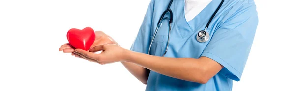 Cropped view of african american nurse with stethoscope showing decorative heart isolated on white, panoramic shot — Stock Photo