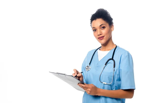 Infirmière afro-américaine avec stéthoscope écrit sur presse-papiers isolé sur blanc — Photo de stock