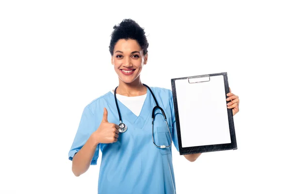 Vista frontale dell'infermiera afro-americana con stetoscopio che mostra appunti e pollice in alto isolato su bianco — Foto stock