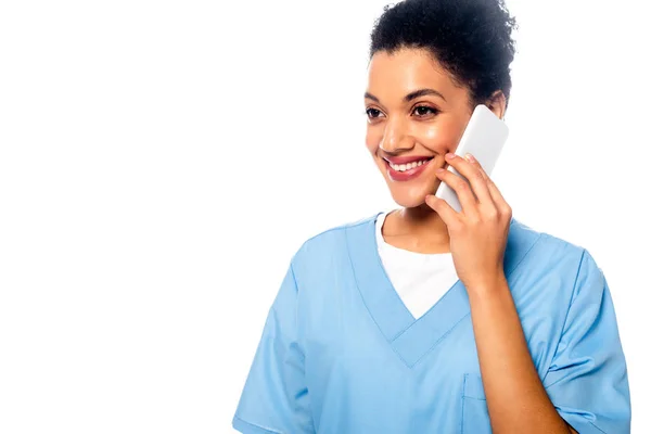 Happy african american nurse talking on smartphone isolated on white — Stock Photo