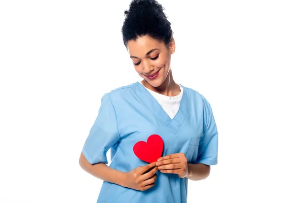 Позитивная африканская медсестра держит декоративное сердце изолированное на белом — стоковое фото