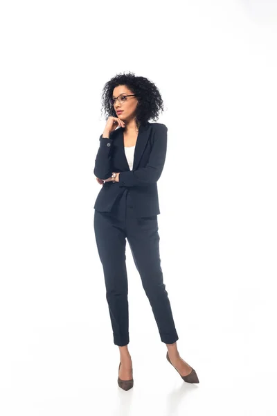 Full length view of confident african american businesswoman in suit with glasses on white background — Stock Photo