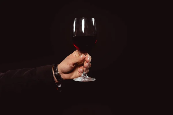 Vista cortada de homem segurando copo de vinho tinto isolado em preto — Fotografia de Stock