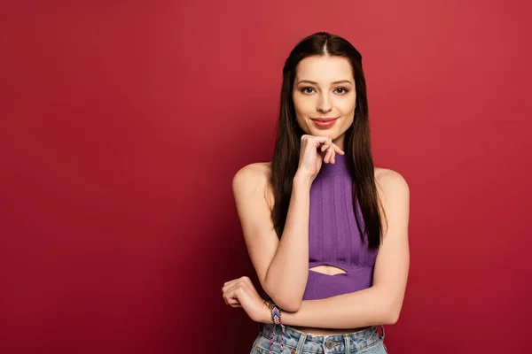 Portrait of smiling brunette woman on red — Stock Photo