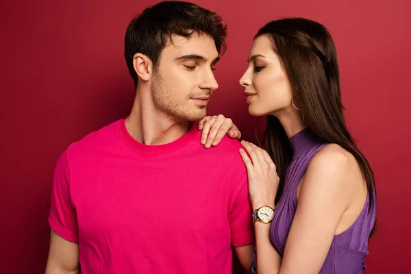 Hermosa pareja joven positiva abrazándose en rojo - foto de stock