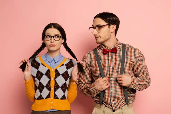 Couple of confused nerds in eyeglasses on pink — Stock Photo