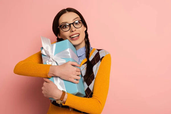 Eccitato nerd femminile in bicchieri che tengono presente su rosa — Foto stock