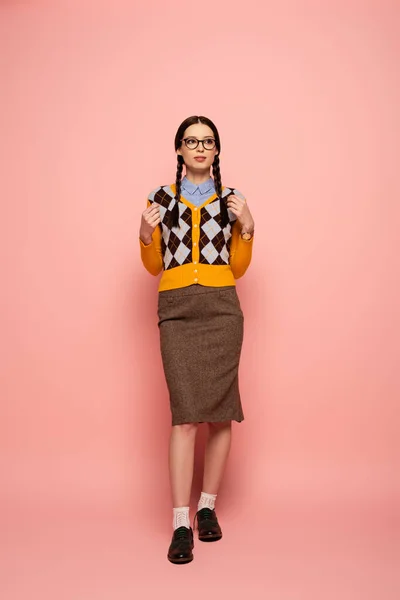 Nerd femelle réfléchie dans des lunettes debout sur rose — Photo de stock