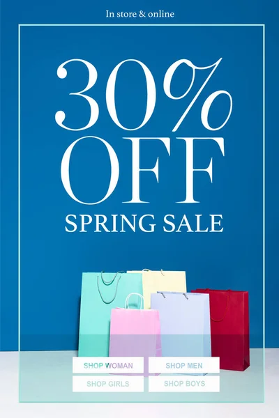 Bolsas de compras de papel de colores sobre fondo azul, 30 por ciento fuera de la ilustración de venta de primavera - foto de stock