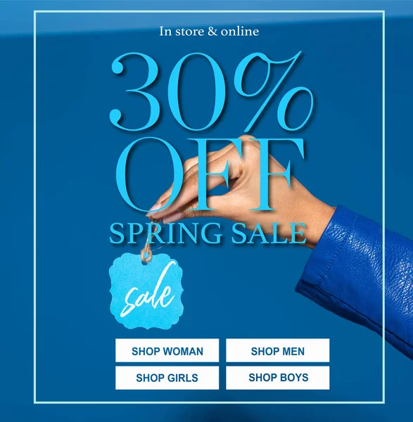Vista ritagliata di donna afro-americana in possesso di etichetta su sfondo blu, 30 per cento off primavera vendita illustrazione — Foto stock