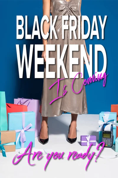 Обрізаний вид афроамериканської жінки в срібній сукні біля платіжного терміналу з чеком, сумками та подарунками на синьому фоні, чорна п'ятниця вихідні ілюстрація — стокове фото