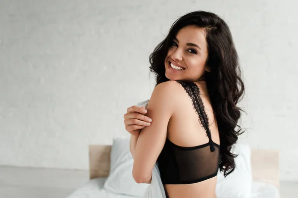 Felice donna seducente in lingerie nera in camera da letto — Foto stock
