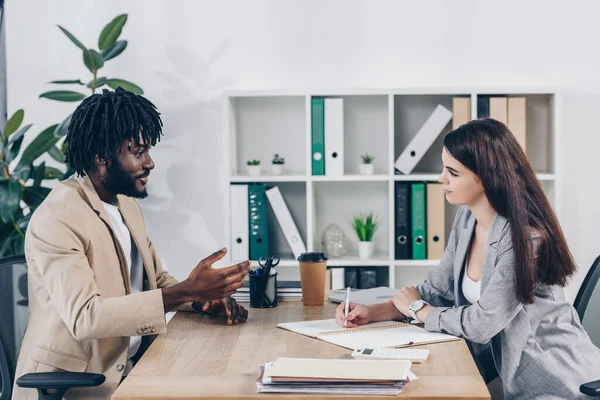 Recrutador e empregado afro-americano conversando em entrevista de emprego no escritório — Fotografia de Stock