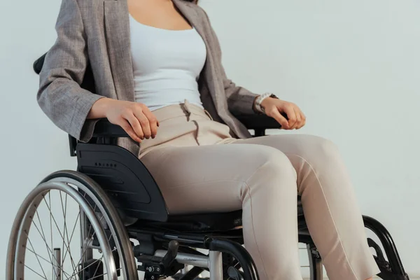 Vista recortada de la mujer discapacitada en silla de ruedas aislada en blanco - foto de stock